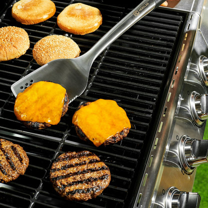 Cheeseburgers on a grill being flipped with a HexClad spatula.
