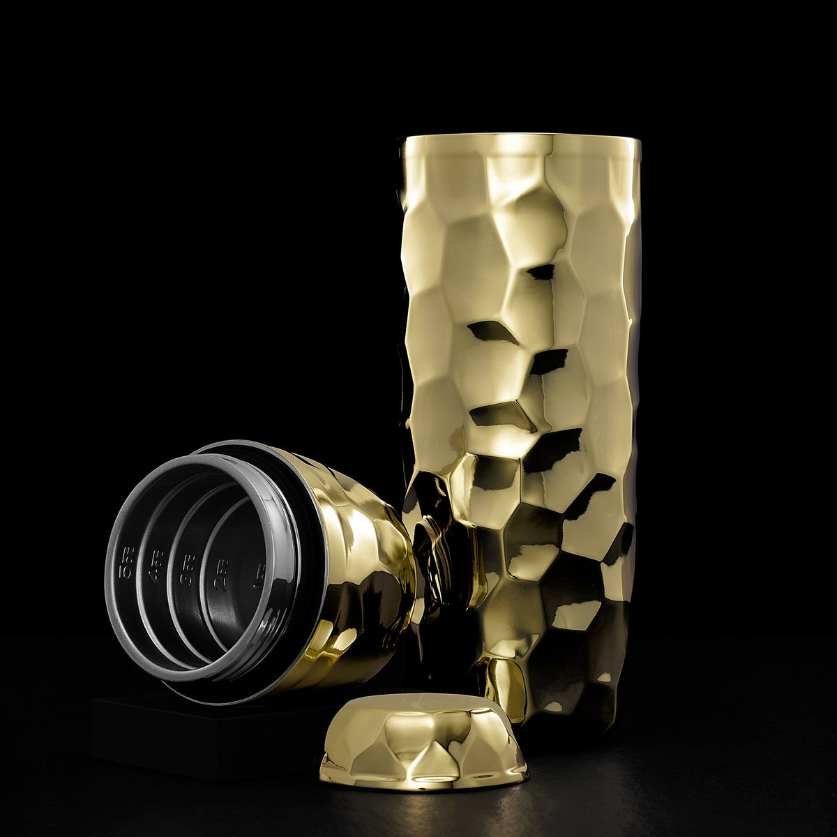 Gold textured COCKTAIL SHAKER with the interior open on a black background